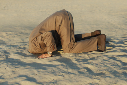 Homme avec sa tête dans le sable